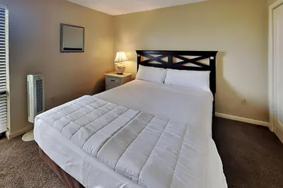 a bedroom with a large bed with white sheets at Edgewater Tower II 905 in Panama City Beach