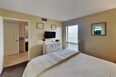 a bedroom with a bed and a flat screen tv at Edgewater Tower II 905 in Panama City Beach