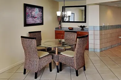 a dining room with a glass table and chairs at Edgewater Tower II 905 in Panama City Beach