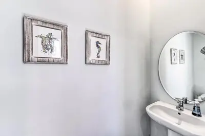 a bathroom with three framed pictures and a mirror at Inlet Beach Escape about half Mi to Beach Access! in Inlet Beach