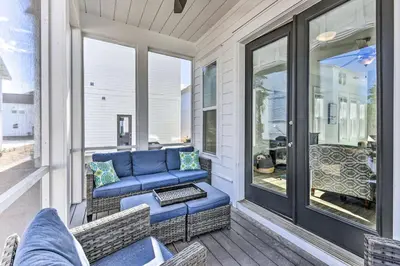 a porch with a blue couch and chairs at Inlet Beach Escape about half Mi to Beach Access! in Inlet Beach