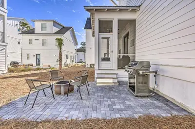 a patio with chairs and a grill in front of a house at Inlet Beach Escape about half Mi to Beach Access! in Inlet Beach