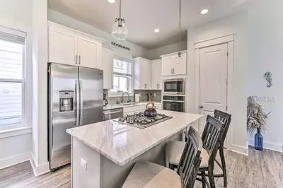 a kitchen with white cabinets and a large island at Inlet Beach Escape about half Mi to Beach Access! in Inlet Beach