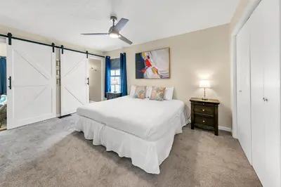 a bedroom with a white bed and a ceiling fan at Sand Castles West T8 in Panama City Beach