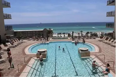 a large swimming pool with people standing around it at Origin at Seahaven in Panama City Beach