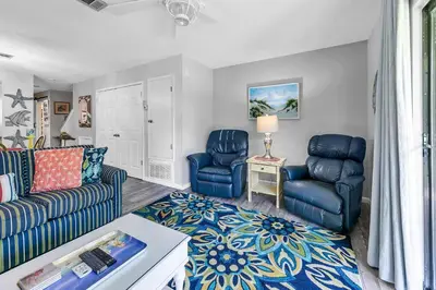 a living room with two chairs and a couch at Portside K5 in Panama City Beach