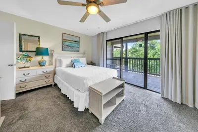 a bedroom with a white bed and a balcony at Portside K5 in Panama City Beach