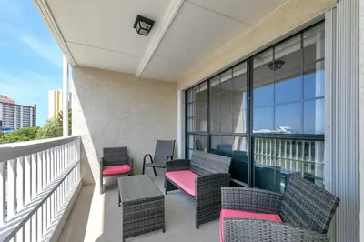 a balcony with chairs and tables on a building at Horizon South 54-303 in Panama City Beach