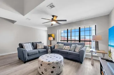 a living room with two couches and a ceiling fan at Horizon South 54-303 in Panama City Beach