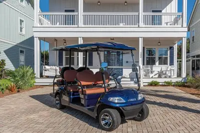 a golf cart parked in front of a house at Blue Dream in Santa Rosa Beach