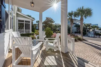 a porch with white chairs on a house at Blue Dream in Santa Rosa Beach