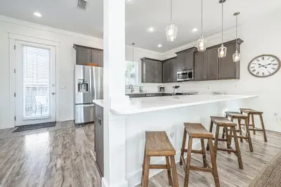 a kitchen with wooden stools and a counter top at Blue Dream in Santa Rosa Beach
