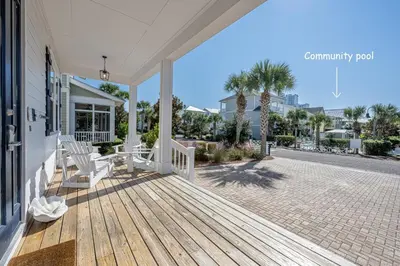 a porch of a house with two white chairs on it at Blue Dream in Santa Rosa Beach