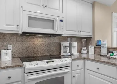 a white kitchen with a stove and a microwave at Treasure Island 2102 Beach Front in Panama City Beach