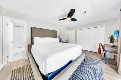 a bedroom with a large white bed and a ceiling fan at Cassine Gardens 273- Kwitcherbeachin' in Santa Rosa Beach