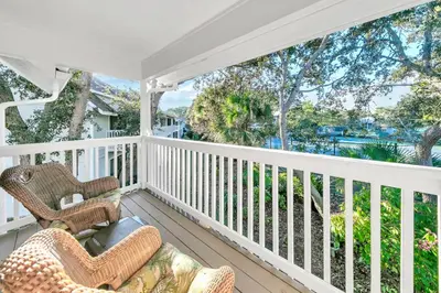 a porch with wicker chairs and a view of the ocean at Cassine Gardens 273- Kwitcherbeachin' in Santa Rosa Beach