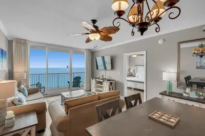 a living room with a dining room table and a view of the ocean at Majestic Beach Towers 1-1804 in Panama City Beach