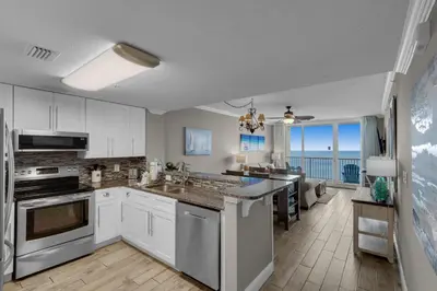 a kitchen with white cabinets and a view of the ocean at Majestic Beach Towers 1-1804 in Panama City Beach