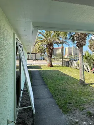 an open door of a building with palm trees at Beautiful House Sleeps 12 - Hot Tub - Breakfast - Walk to Beach in Panama City Beach