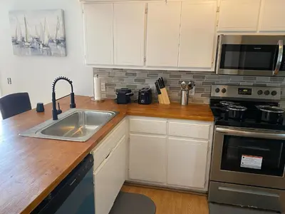 a kitchen with white cabinets and a sink at Beautiful House Sleeps 12 - Hot Tub - Breakfast - Walk to Beach in Panama City Beach