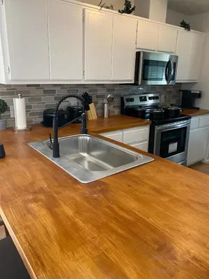 a kitchen with a sink and a wooden counter top at Beautiful House Sleeps 12 - Hot Tub - Breakfast - Walk to Beach in Panama City Beach
