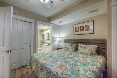 a bedroom with a large bed and a white door at Grand Panama 2-307 in Panama City Beach