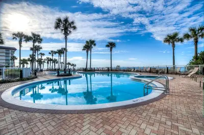 a large swimming pool with palm trees in the background at Grand Panama 2-307 in Panama City Beach