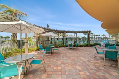 a patio with tables and chairs and umbrellas at New Calypso Beach Resort Corner Unit Sleeps 8! by Dolce Vita Getaways PCB in Panama City Beach