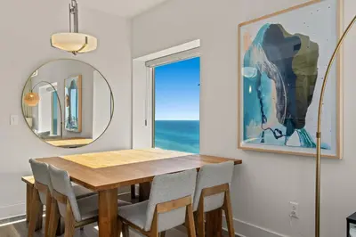 a dining room with a table and chairs and a mirror at New Calypso Beach Resort Corner Unit Sleeps 8! by Dolce Vita Getaways PCB in Panama City Beach