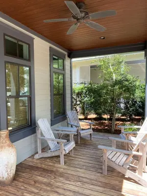 a porch with rocking chairs and a ceiling fan at The Summer Palace in Inlet Beach