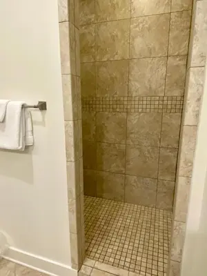 a shower in a bathroom with a tiled floor at The Summer Palace in Inlet Beach