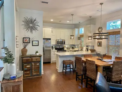a large kitchen with a wooden table and chairs at The Summer Palace in Inlet Beach