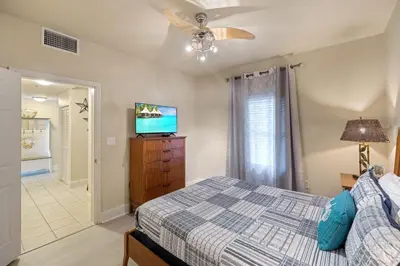 a bedroom with a bed and a flat screen tv at Stunning Resort Low Floor Condo! Sleeps 8! Steps 2 Beach & Restaurants! by Dolce Vita Getaways PCB in Panama City Beach