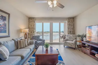 a living room with a couch and a tv at Stunning Resort Low Floor Condo! Sleeps 8! Steps 2 Beach & Restaurants! by Dolce Vita Getaways PCB in Panama City Beach
