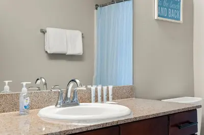 a bathroom counter with a sink and a mirror at Stunning Views! located Steps 2 Beach, Restaurants & Shops! by Dolce Vita Getaways PCB in Panama City Beach
