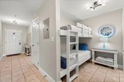 a room with two bunk beds and a staircase at Stunning Views! located Steps 2 Beach, Restaurants & Shops! by Dolce Vita Getaways PCB in Panama City Beach