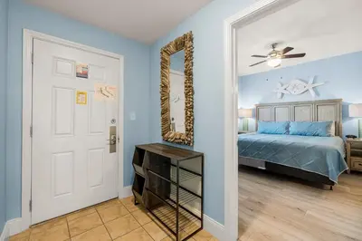 a bedroom with a bed and a mirror at Lovely Resort Low Floor Condo! Just Steps to the Beach & Restaurants! by Dolce Vita Getaways PCB in Panama City Beach
