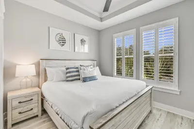a white bedroom with a bed and two windows at 30A Pet Friendly Beach House - Seacrest Serenity by Panhandle Getaways in Inlet Beach