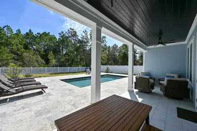 a patio with a pool and a table and chairs at 30A Pet Friendly Beach House - Seacrest Serenity by Panhandle Getaways in Inlet Beach