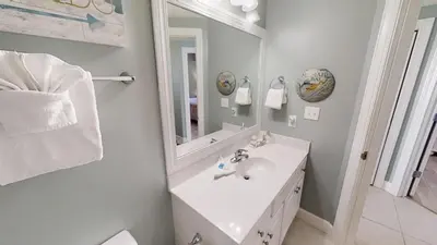 a white bathroom with a sink and a mirror at Sunrise Beach 1408 in Panama City Beach