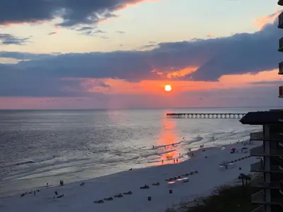 a view of a beach with people and a pier at Gulf front condo in Panama City Beach