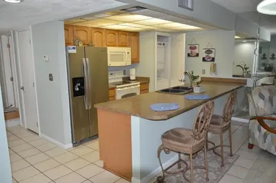 a kitchen with a counter and a refrigerator at Gulf front condo in Panama City Beach