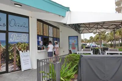 two people are standing outside of a restaurant at Gulf front condo in Panama City Beach
