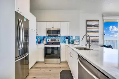 a kitchen with a sink and a stove top oven at Shores of Panama 2003 - Renovated 2 bedroom, with Bunkroom Sleeps 6 with a Reserved Parking Space! condo in Panama City Beach