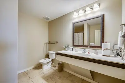 a bathroom with a sink and a toilet and a mirror at Origin at Seahaven 403 - Spacious 3 Bedroom withSunset View! Free Fun! condo in Panama City Beach