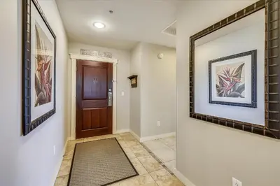 a hallway with a door and paintings on the walls at Origin at Seahaven 403 - Spacious 3 Bedroom withSunset View! Free Fun! condo in Panama City Beach