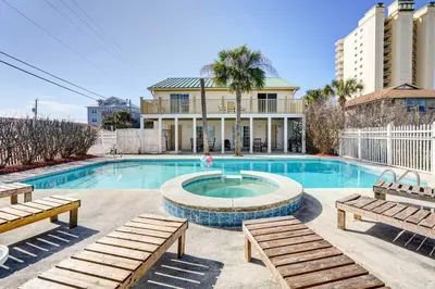 a swimming pool with benches in front of a building at Private Pool and Hot Tub at Panama City Home! in Panama City Beach