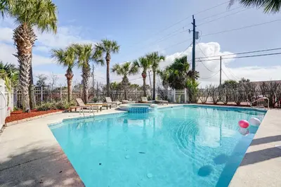 a swimming pool with palm trees in the background at Private Pool and Hot Tub at Panama City Home! in Panama City Beach