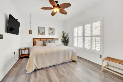 a bedroom with a bed and a ceiling fan at Spring Break Friendly Ages 21–25+ OK in Panama City Beach