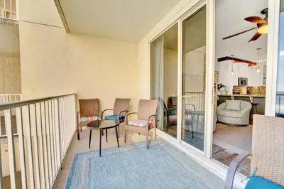 a room with a balcony with chairs and a table at Spring Break Friendly Ages 21–25+ OK in Panama City Beach